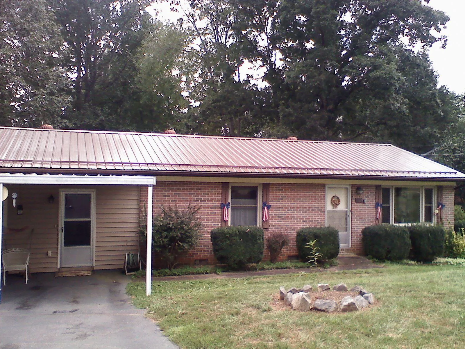 Bronze metal roof and carport on a brick ranch home — Roof Repair work by our crew in Willards